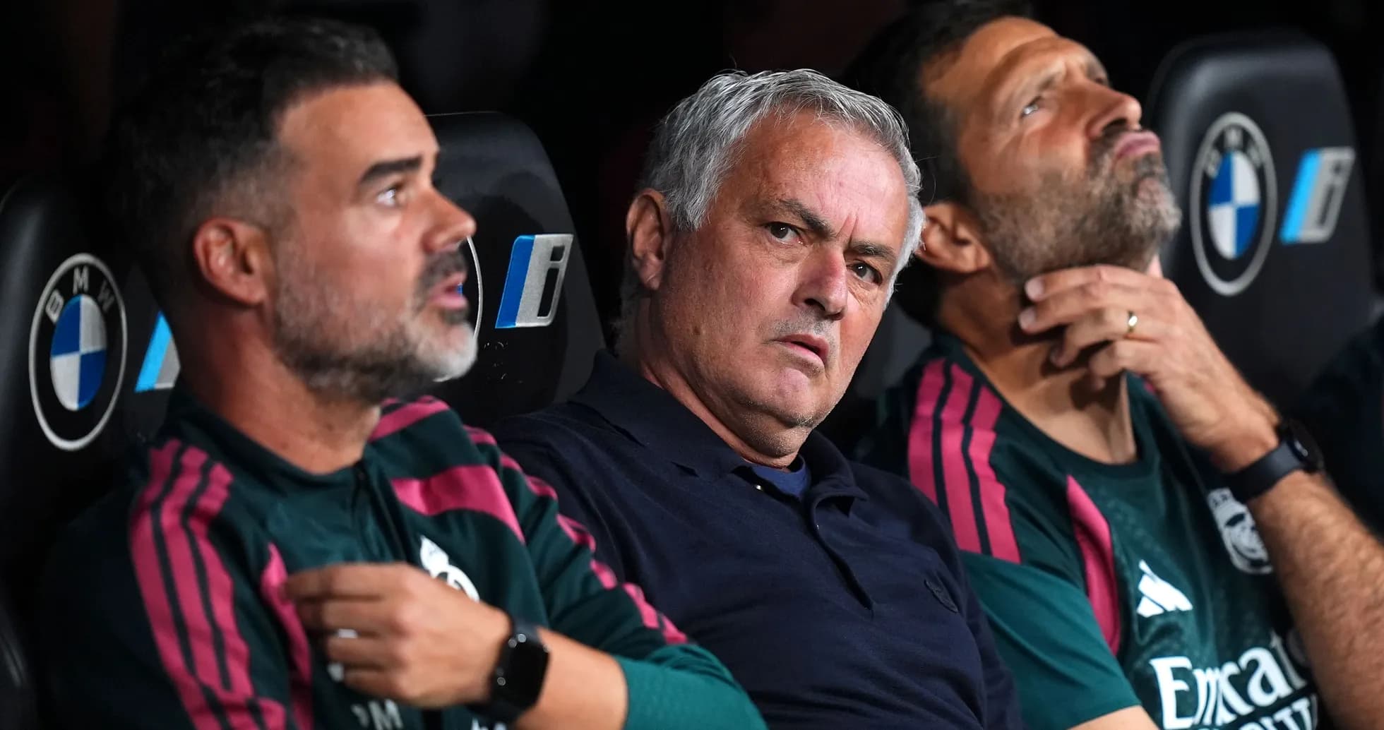 Coaching staff seated on bench during match