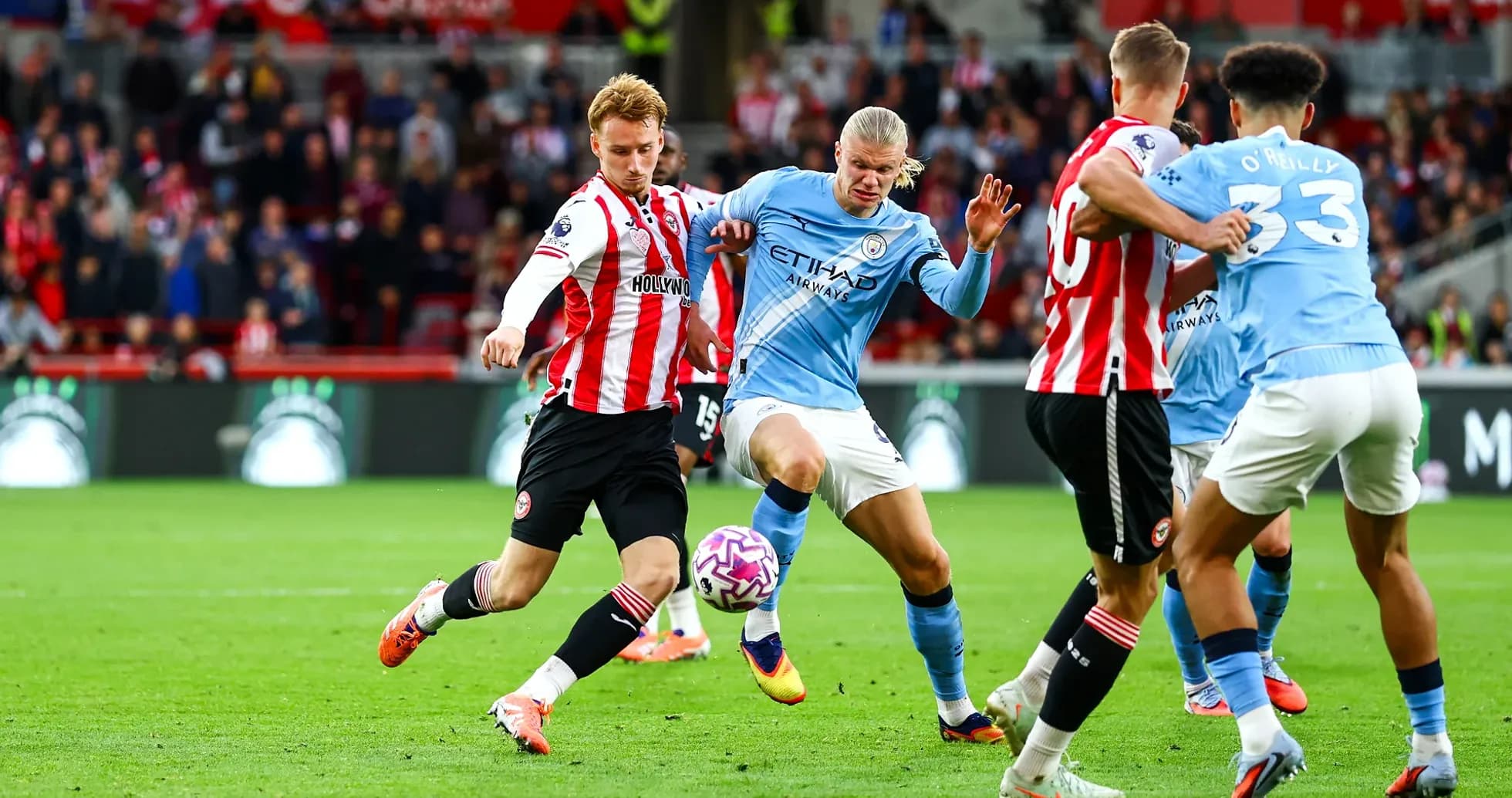Manchester City player challenging Brentford opponent