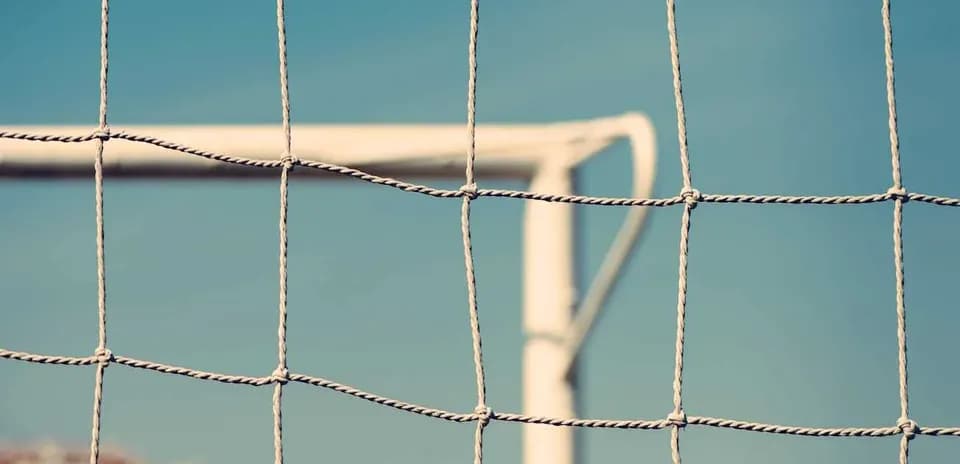 Close-up of a soccer goal net against sky