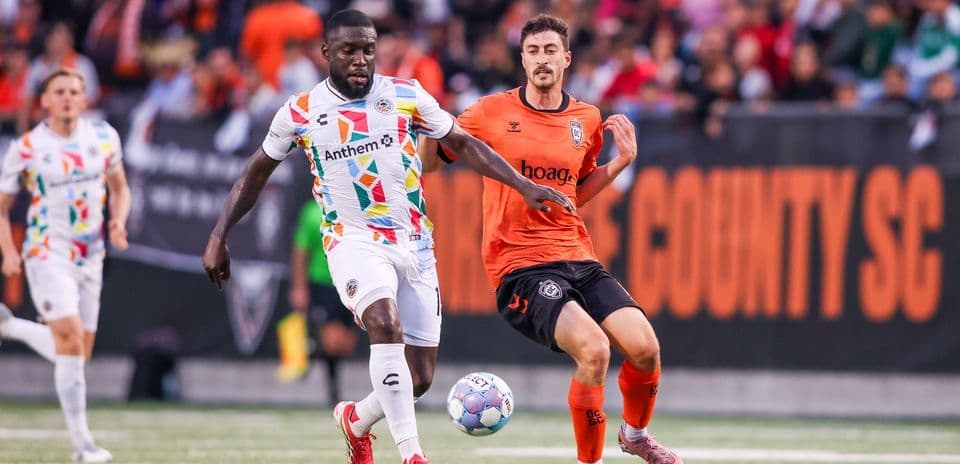 Oakland Roots player dribbling against Colorado Springs