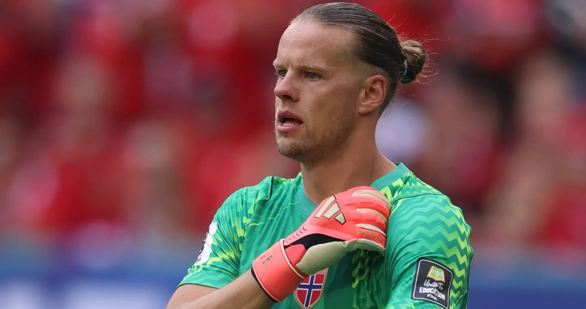 Goalkeeper in green kit preparing for play