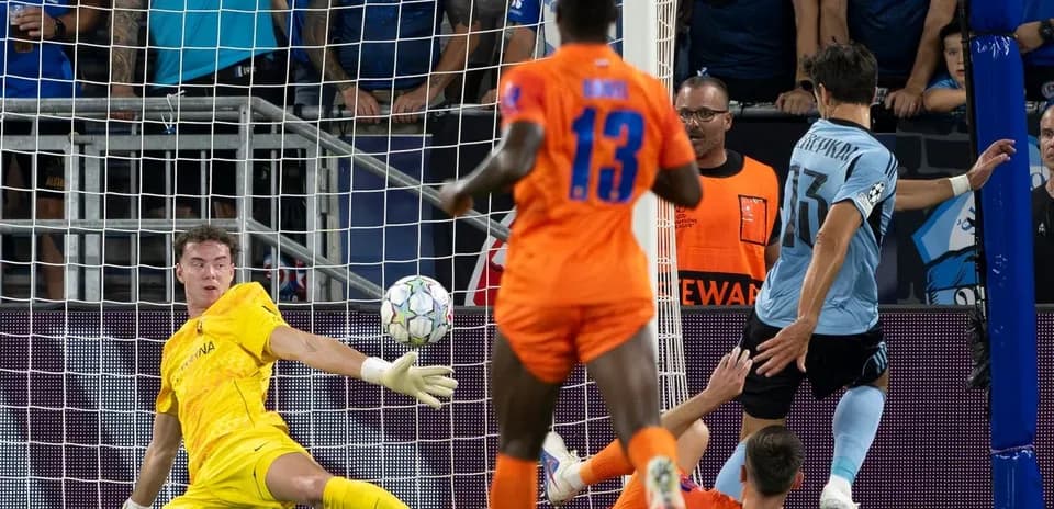 Goalkeeper saving a shot during UEFA match