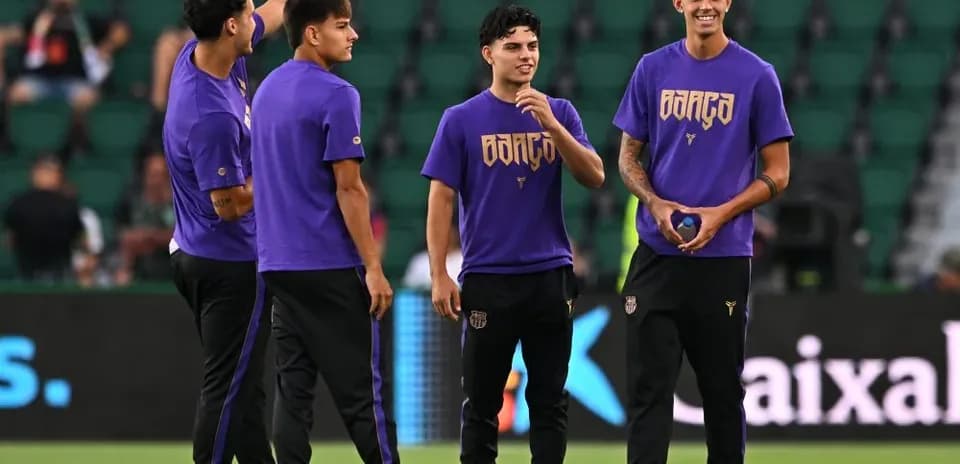 Players in purple jerseys warming up on field