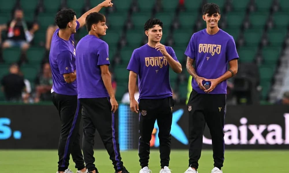 Players in purple jerseys warming up on field