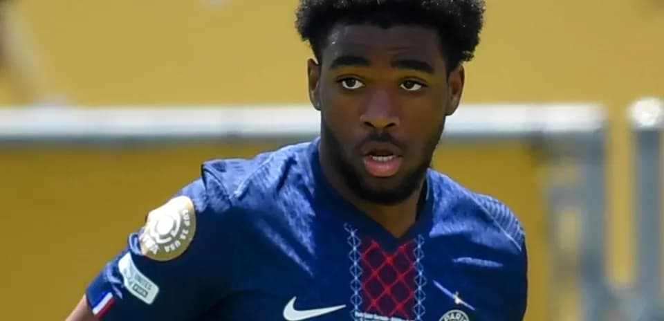 Player in PSG jersey running on the field