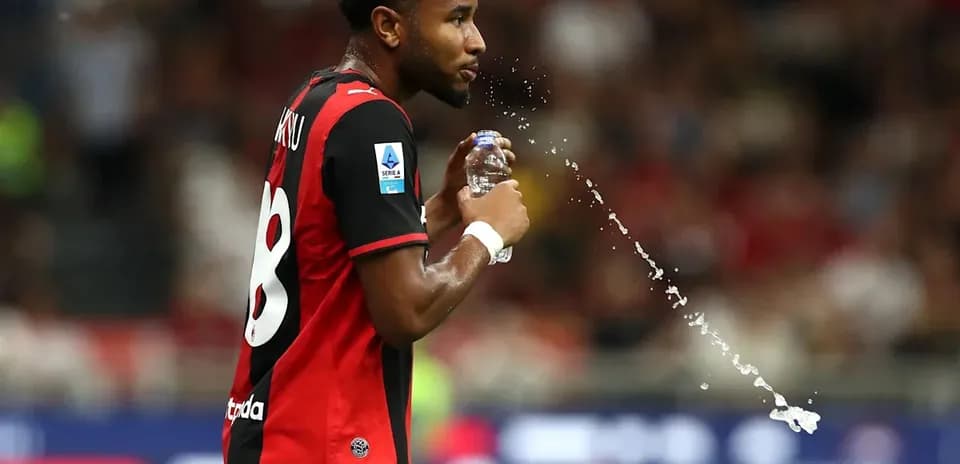 Player spraying water from a bottle on the field