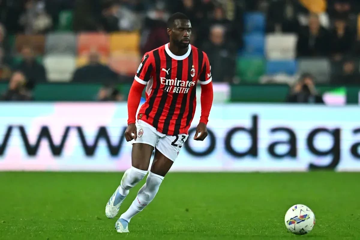 Player in AC Milan kit dribbling ball on field