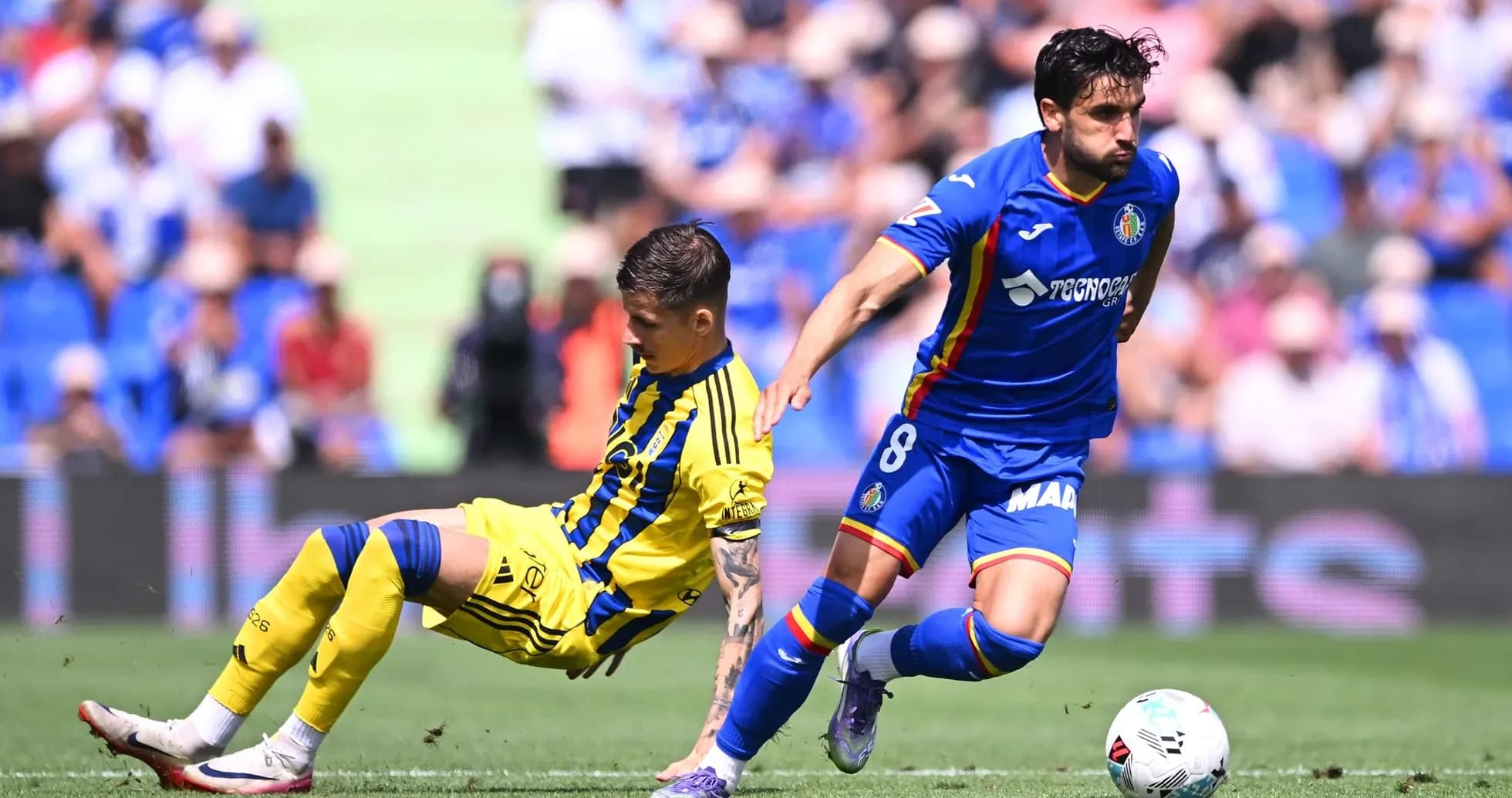 Getafe player dribbling past Oviedo opponent