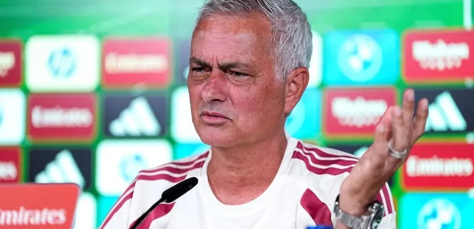 Manager speaking at press conference with backdrop