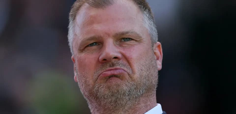 Coach looking on during match with serious expression