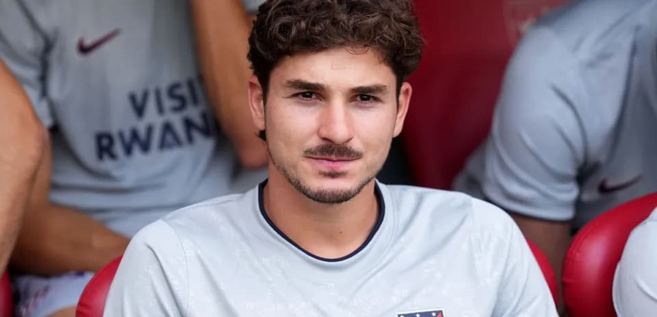 Player sitting on bench in Atlético Madrid kit