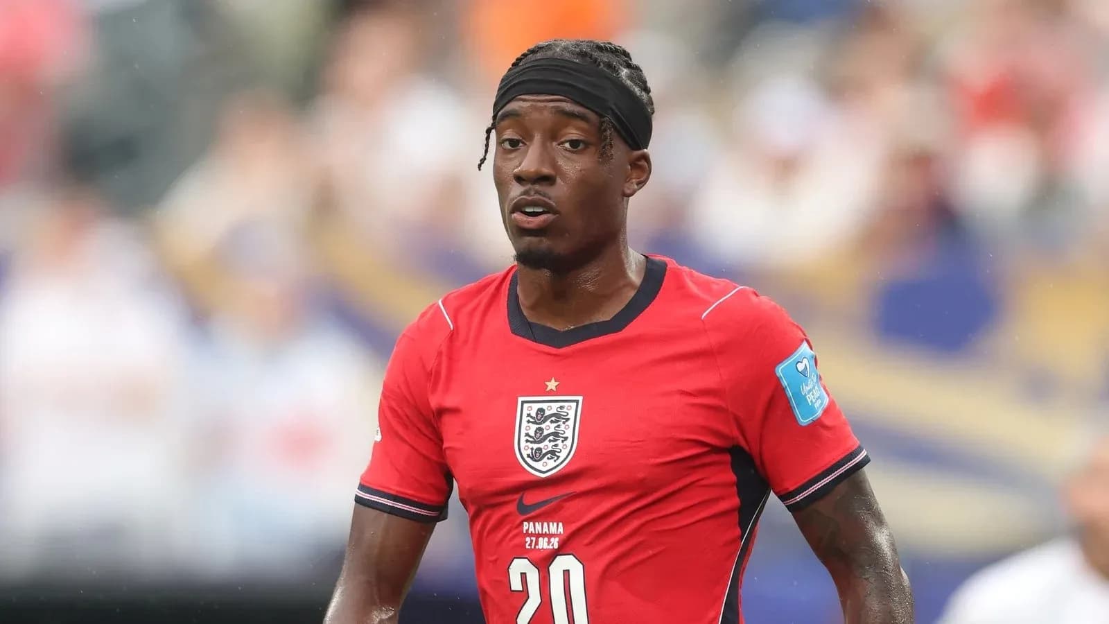 Player in red England jersey during match action
