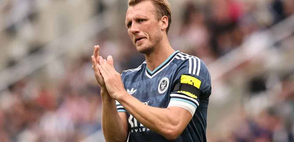 Player clapping with captain's armband on field