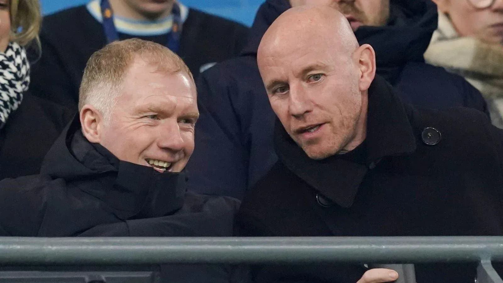 Two men conversing in stadium seats