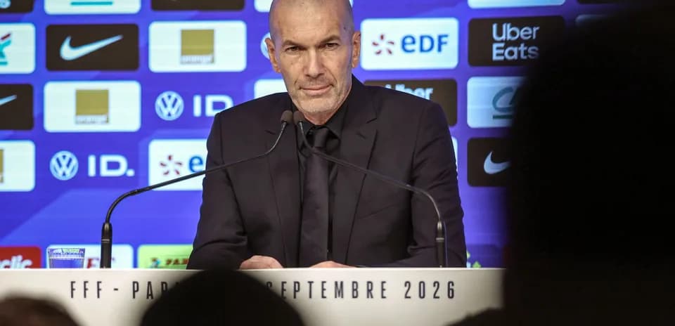 Manager speaking at press conference with sponsors' logos