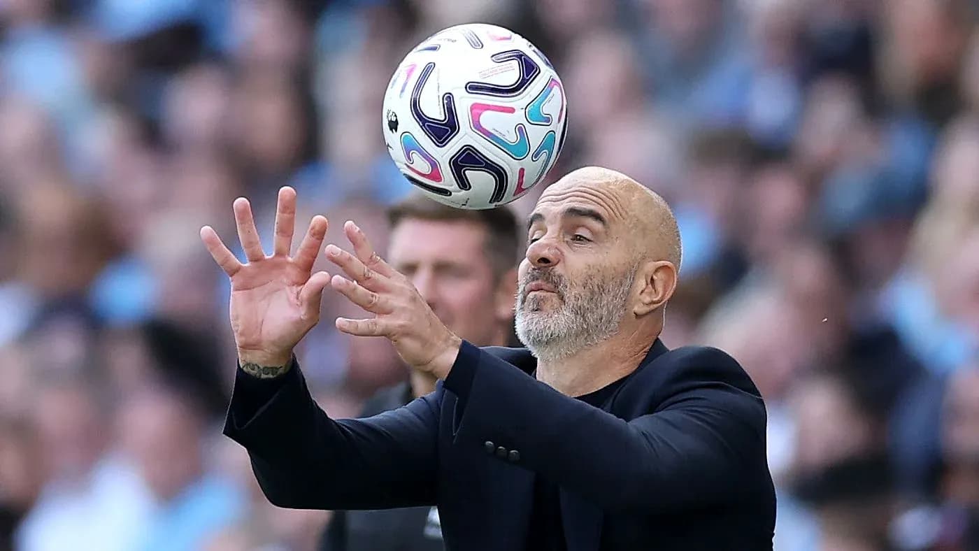 Coach attempting to catch a football during match