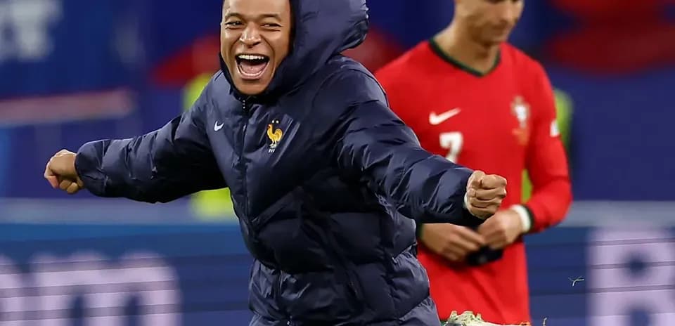 Kylian Mbappé celebrating on the field with Cristiano Ronaldo