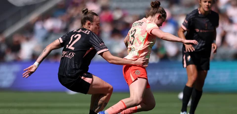 Player tackles opponent during NWSL match