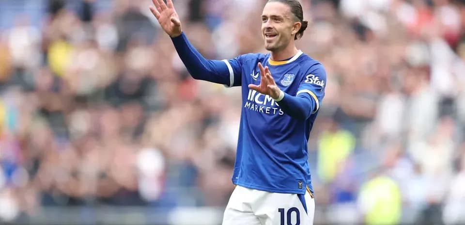 Player in blue jersey gesturing to fans during match