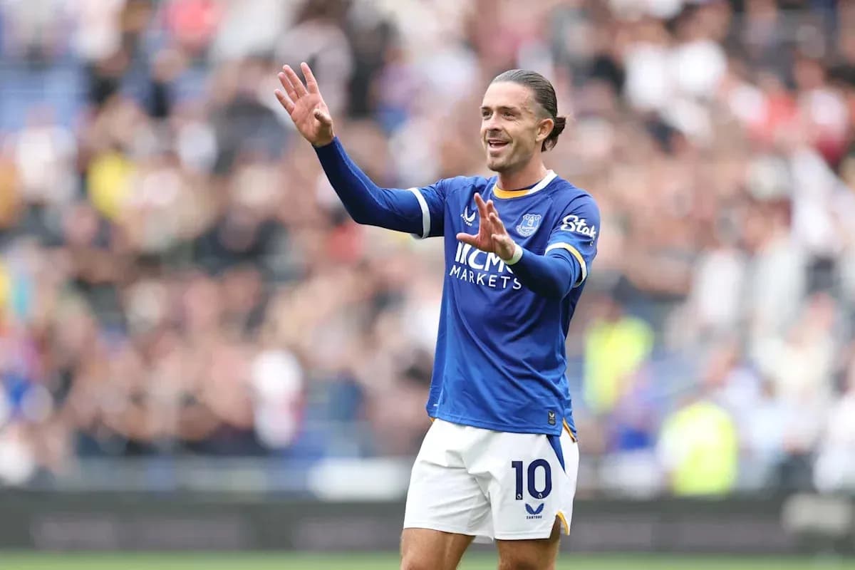 Player in blue jersey gesturing to fans during match