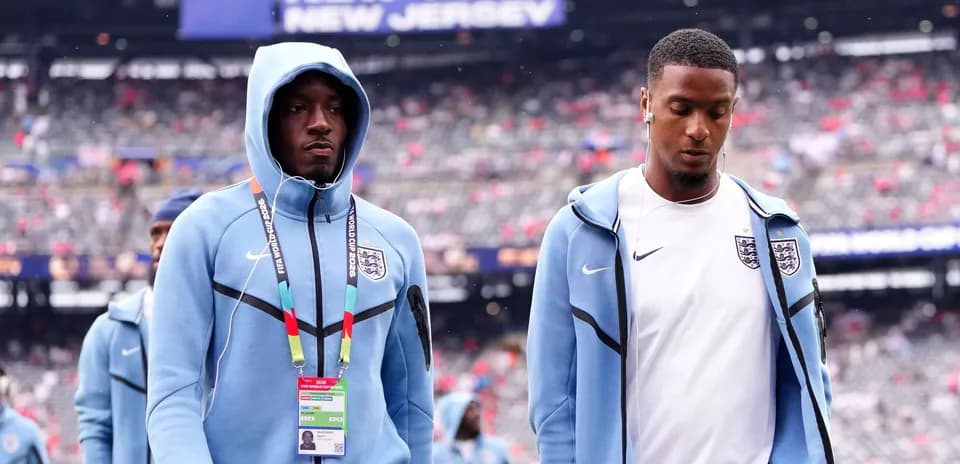 Two England players walking onto the pitch