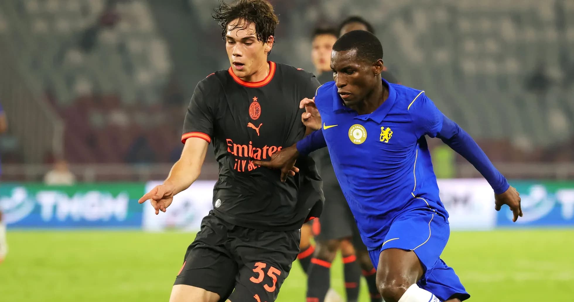 Players from AC Milan and Chelsea competing for the ball