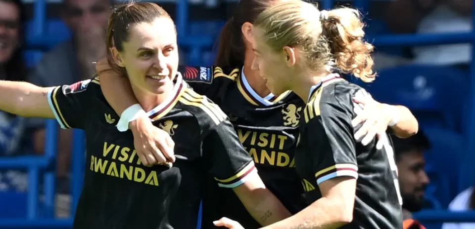 Three players celebrating a goal on the field