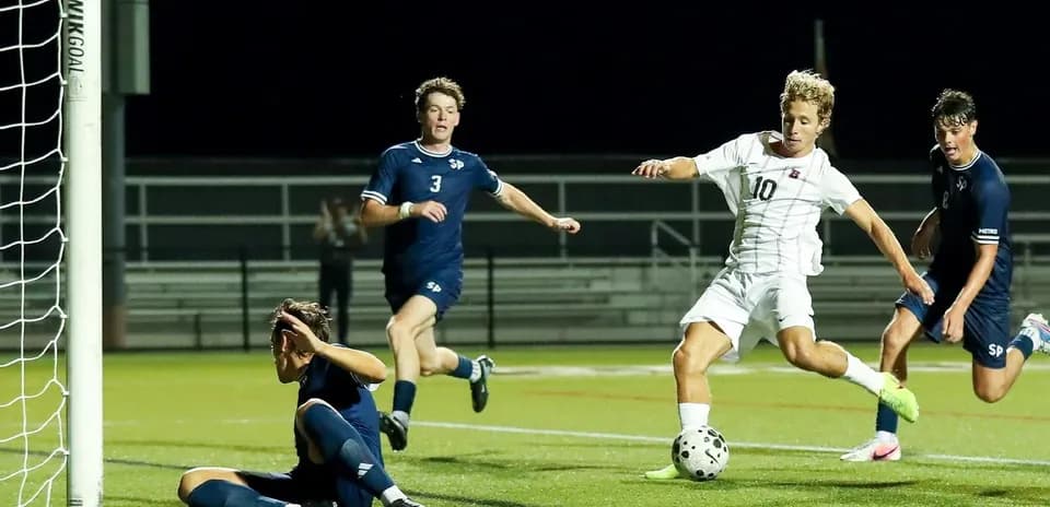 Player attempting to score as goalkeeper reacts