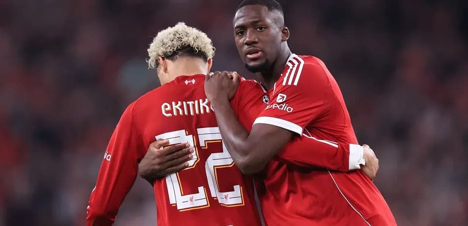 Two players embracing on the pitch during match