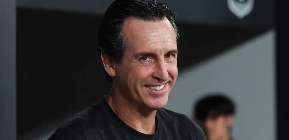 Coach smiling during match preparations on sidelines