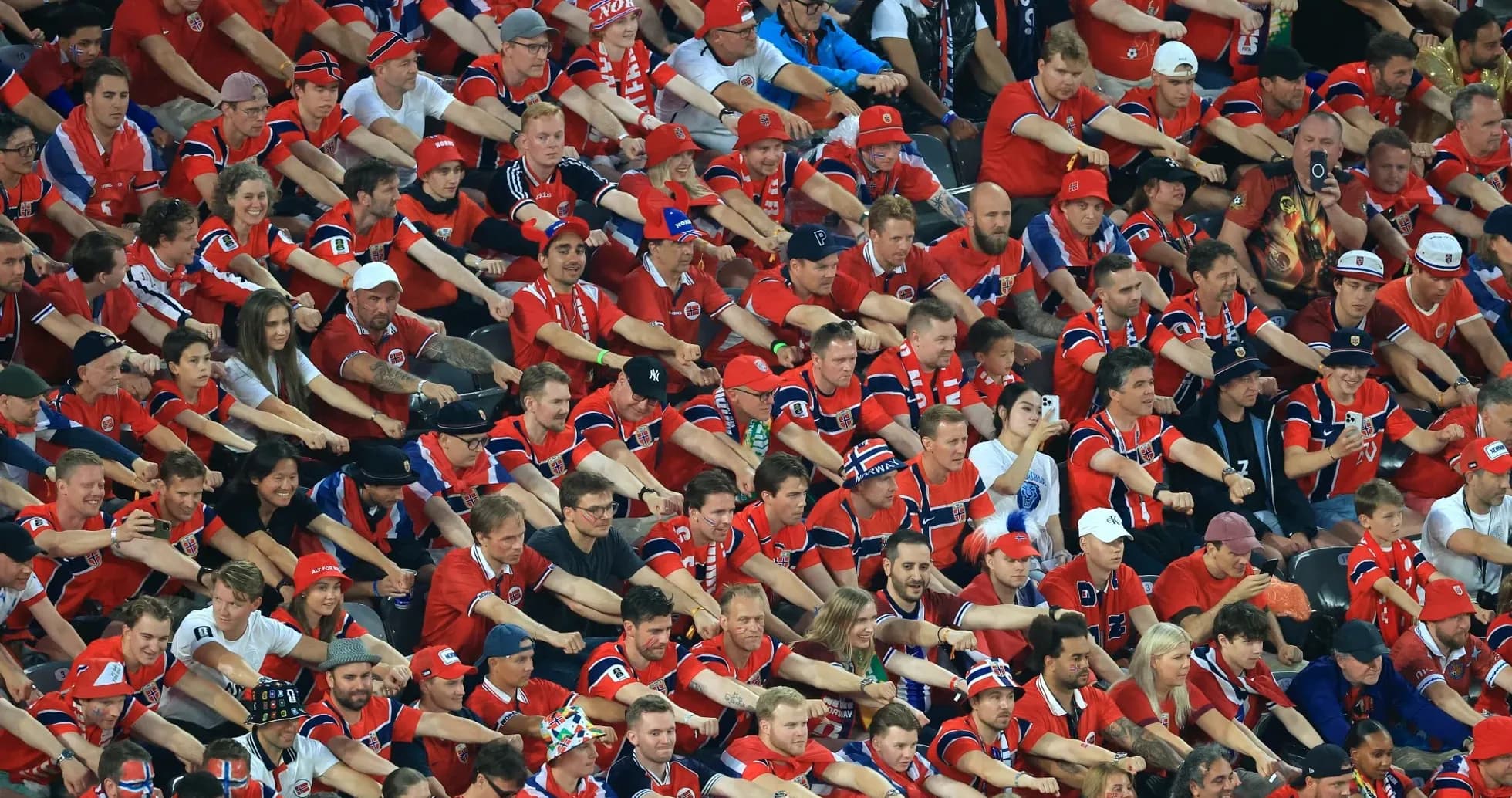 Crowd of fans in red jerseys cheering at event
