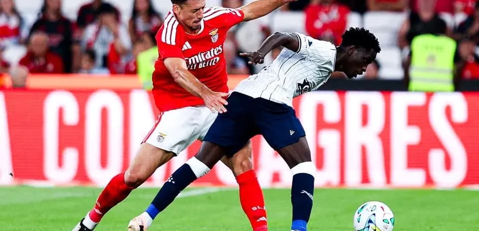 Benfica player challenging Aarhus opponent for ball