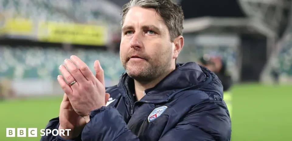 Coach clapping in stadium after match conclusion