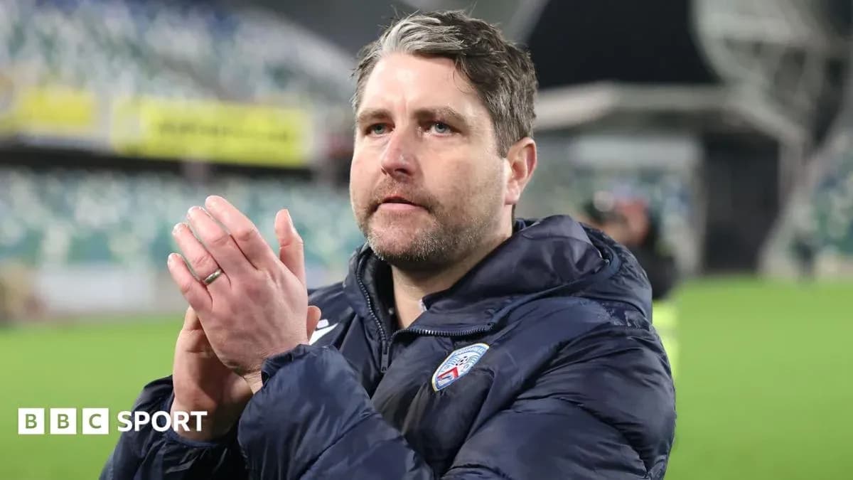 Coach clapping in stadium after match conclusion