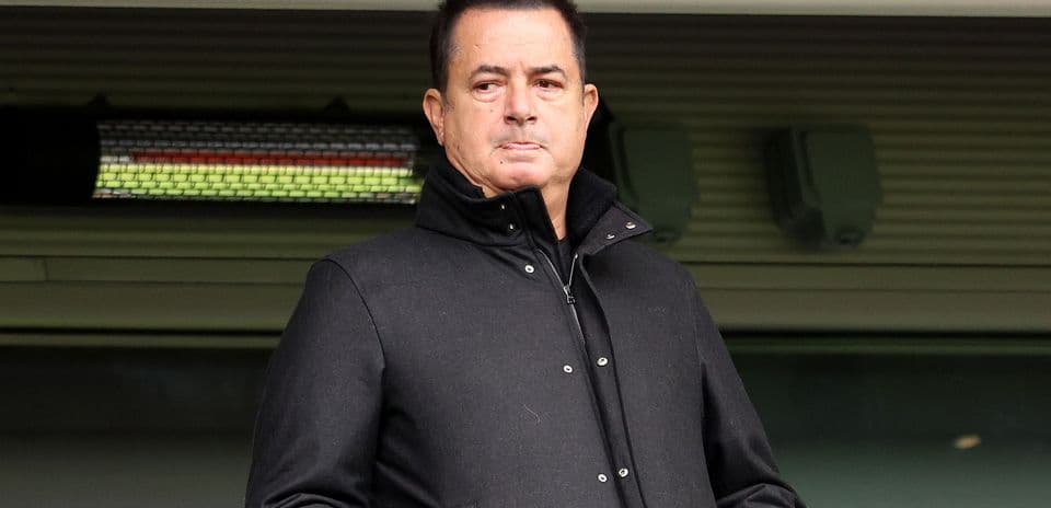 Man in a black coat standing in a stadium