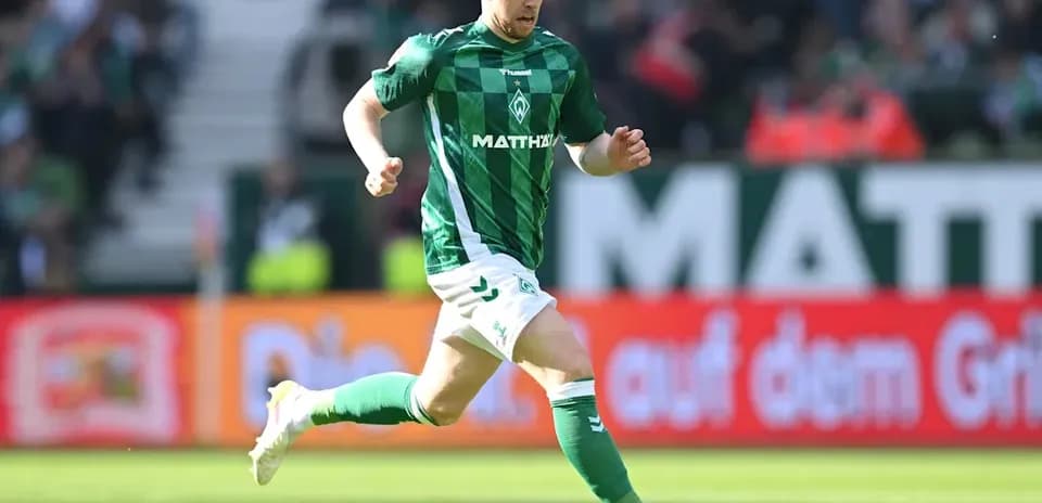 Player in green jersey running with the ball