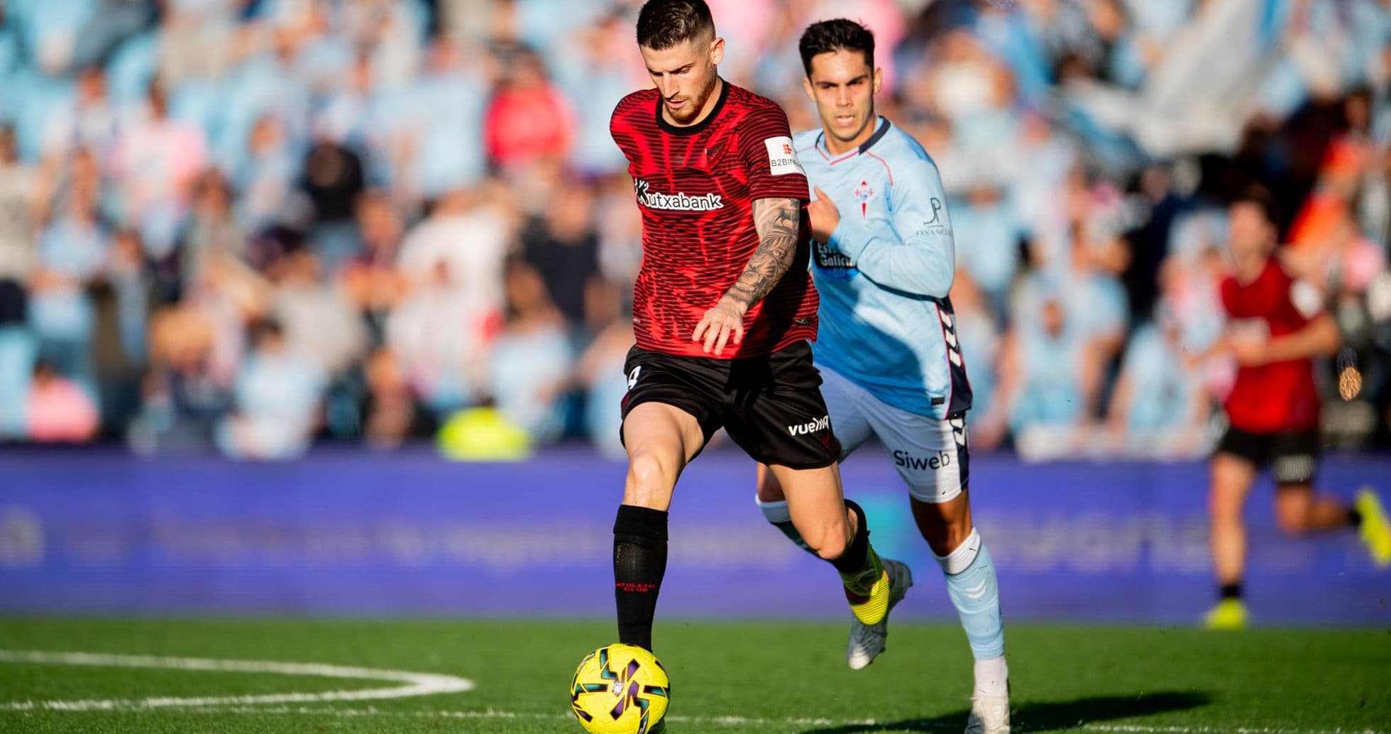 Athletic Club player dribbling past Celta Vigo defender