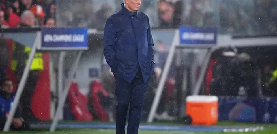 Coach standing on the sideline during rainy match