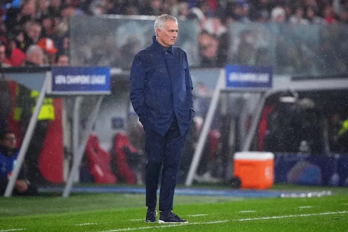 Coach standing on the sideline during rainy match