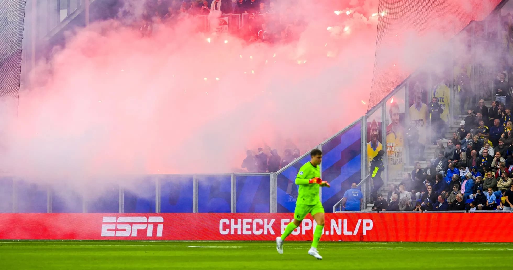 Goalkeeper walking past smoke and flares during match