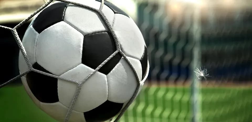 Soccer ball in goal net at stadium