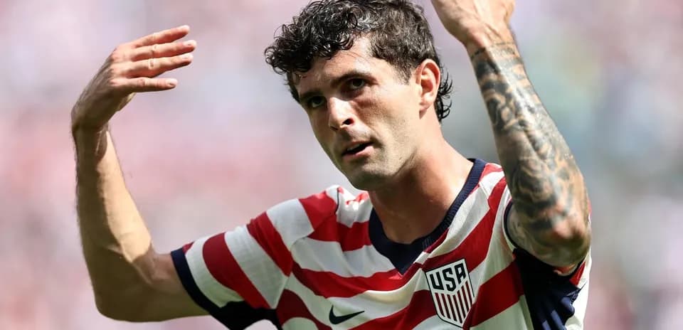 Player gesturing during soccer match wearing USA jersey