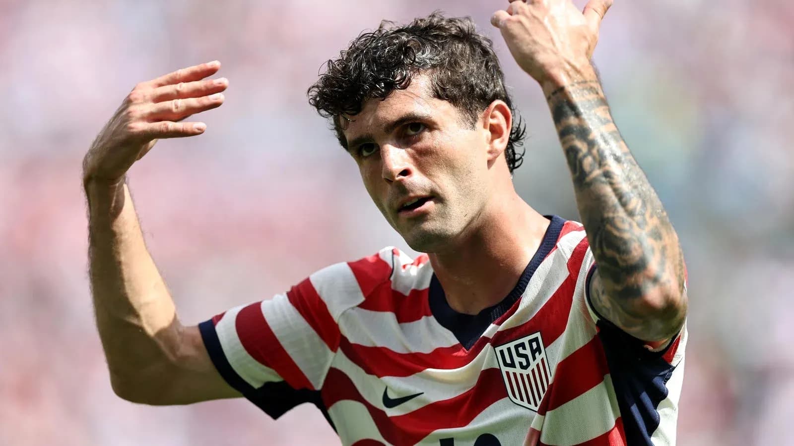Player gesturing during soccer match wearing USA jersey