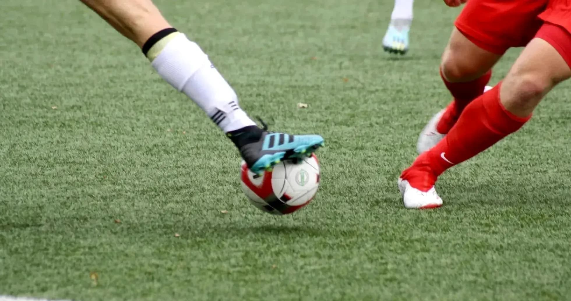 Players competing for the ball in football match