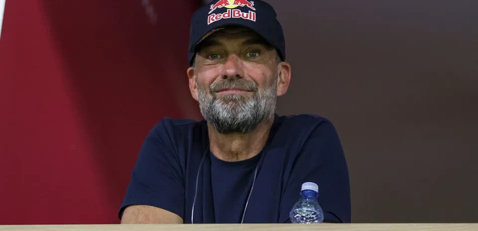 Man in a Red Bull cap observing from a balcony