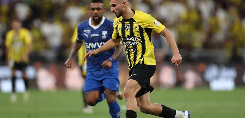 Player in yellow jersey dribbling past opponent in blue