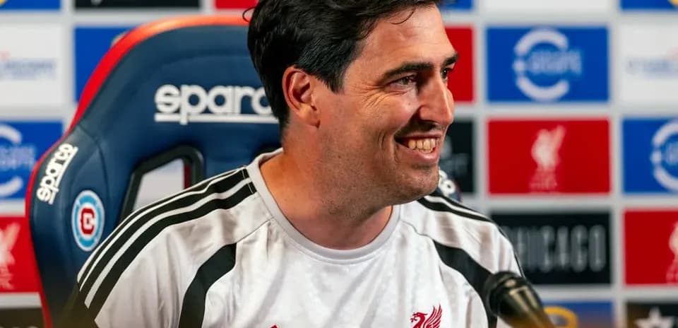Manager speaking at press conference with Liverpool branding