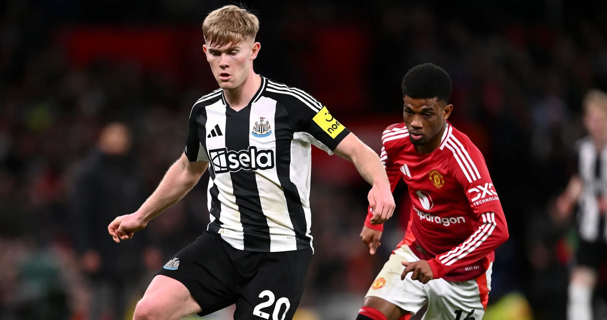 Newcastle player dribbling past Manchester United opponent