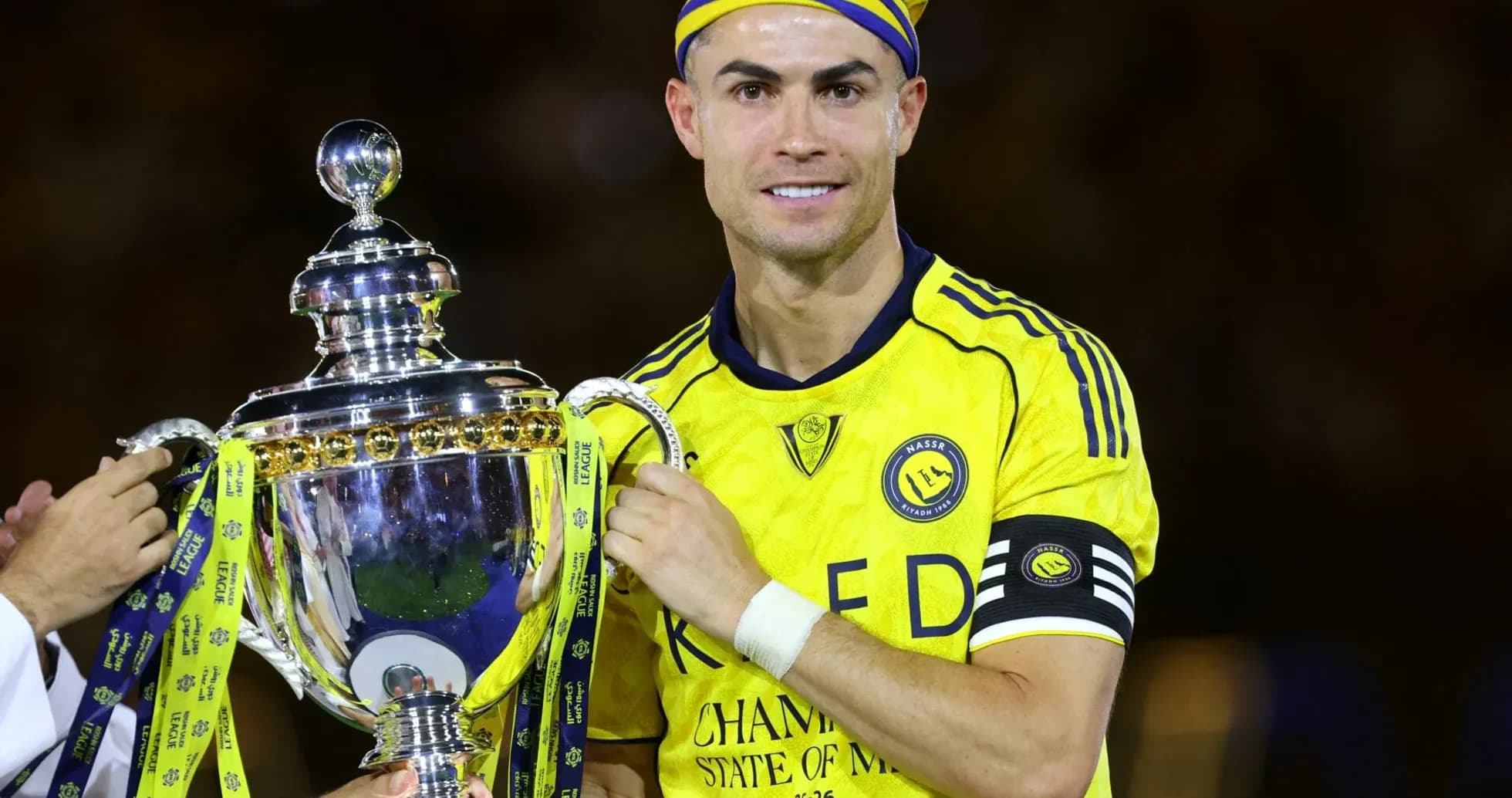 Player holding trophy in yellow team jersey
