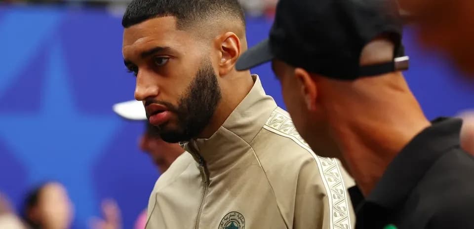 Player in team jacket talking with another person